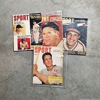 Photo of five vintage SPORT magazines with covers featuring baseball players including Mickey Mantle and Stan Musial. Magazines show signs of used condition.
