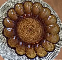 Top view of vintage amber glass hobnail egg plate showing 12 egg-shaped compartments and raised hobnail texture in the center