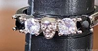 Close-up image showing ring with two black rhinestones, two clear rhinestones, and central skull design.