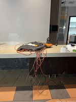 View of Worx WG508 blower, extension cords and vacuum bag on countertop.