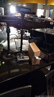 Photo showing a surface with two Radiant brand POS customer display pole screens, a cardboard box, cash register drawers, and some cables and cords.