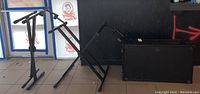 Two Proline stands and one Gator Frameworks adjustable stand shown from side on floor against a black backdrop