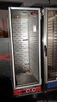 Full front view of the BrevLes heated food proofer showing glass door, interior racks, and lower control panel with knobs.