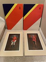 Two of the eight RCMP 100th Anniversary prints partially removed from original protective multicolor sleeves showing officers in red serge uniform with detailed illustrations