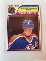 Front of the hockey card showing Wayne Gretzky in Edmonton Oilers uniform with helmet, NHL logo, and text indicating 1984-1985 Goal Scoring Leaders.
