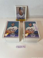Two complete stacks of 1991 Pacific Ryan Texas Express I baseball card sets in clear protective cases with a sealed baseball card cello pack standing behind.