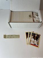 A white storage box filled with 357 OHL hockey cards from 1990-1991 season. Several cards are partially fanned out next to the box to show design.