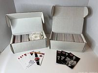 Two open white cardboard boxes containing numerous collectible Elvis Presley trading cards from 1992, some loose cards displayed in front of boxes.