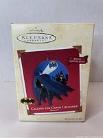 Photo of the front of the Batman Hallmark Keepsake Ornament box showing the ornament's design and special lighting effect claim.