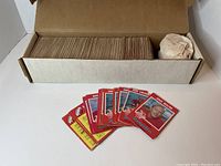 Open box showing a large stack of 1971 CFL trading cards with some individual cards fanned out in front, depicting player portraits and team names.