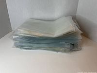 Stack of over 300 comic book covers in clear protective sleeves layered and stacked against a plain white background.