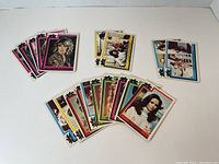 Photo showing multiple Charlie's Angels trading cards arranged in four groups with different colored borders - pink, yellow, blue, and multicolored.