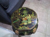 Top view of the decorative table showing detailed hand-painted scene with figures and plants.