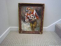 Framed painting of football player leaning against wall near staircase, shown in full view.