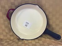 Top view of the 12-inch frying pan showing cream-colored interior, black rim, and black handle with hanging hole.
