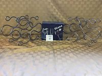 Two silver-toned metal wine racks with swirl design and six crystal wine glasses in original Diana box
