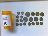 21 Australian coins of various denominations laid out with an orange plastic pill bottle.