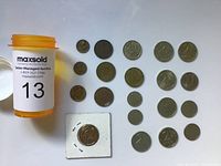 Photo showing 20 assorted Russian coins of various sizes and denominations placed neatly on a flat surface next to auction container group.
