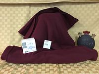 King size burgundy fleece throw displayed over chair, small tabletop chalk sign stating 'EAT BEEF!' on right, cellulite shaker massager box placed in front.