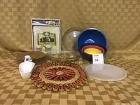 Overall shot of lot, showing all pieces including mixing bowls, pie plates, trivets, cheese tray, salt and pepper shakers, and tray set in packaging.