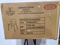 Box with product details showing mid-century modern dining chair by CSP with white polypropylene frame and natural beechwood legs