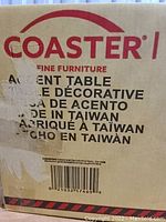 Photo of cardboard packaging box labeled Coaster Fine Furniture Accent Table, made in Taiwan.