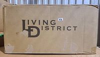 Brown cardboard box with Living District branding and a small label marked 52.
