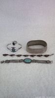 Four bracelets and one ring shown together on a light background.