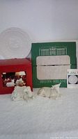 Photo showing the Belleek Christmas plate in its original green box and the Manger ox and camel figurines in front with red box.