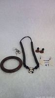 Photo showing black African necklace with black spherical beads and a square black-and-cream patterned pendant, round wooden bangle, and various earrings including cream, tortoiseshell and black-and-cream styles.
