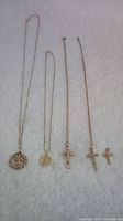 Overview of five necklaces and pendants on white background