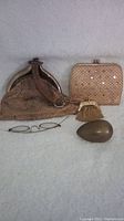Photo showing the Whiting & Davis metal mesh handbag, matching detachable coin purse, spectacles, and brass egg on a light background.
