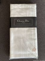 Front view of the folded white handkerchiefs in original packaging with Christian Dior label.