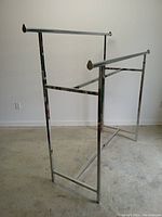 Angle view of adjustable chrome double rail clothing rack showing side profile and rails.