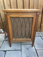Full front view of wooden speaker box showing lattice design, fabric grill, wooden fluted corners, and overall condition.