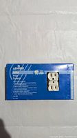 Box front showing Leviton branding, product count (10 outlets), and visible duplex outlet through the packaging window.