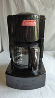 Front view of Coleman camping coffeemaker with glass carafe in place.