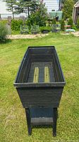 Front angled view of the planter box showing interior with bottom filter plate and drain slots.