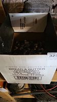 Closer view inside the box showing clamps and the box label indicating prior use for bottles.