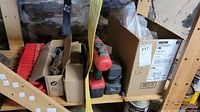 Power Max drill with red and black casing, stored on a wooden shelf with three cardboard boxes containing various hardware and pool items.