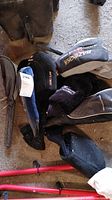 Seven assorted golf club covers in mixed colors and brands placed on floor.