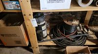 Hayward pool pump unit positioned on lower shelf next to electrical wiring and accessories.