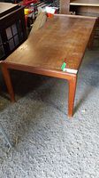 Angle view of wood coffee table showing wear and rounded leg edges