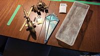 All four items shown on wooden table: brass helicopter, elephant windchime bells, stained glass suncatcher, slag glass dish
