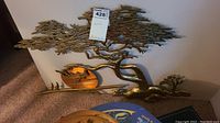 Front view of brass Asian tree wall hanging showing intricate branches and a circular sun element.