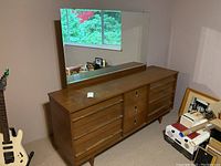 Full view of dresser with mirror against wall