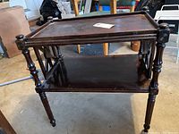 Side view of the vintage wood side table showing turned legs, lower shelf and finial decoration on corners.