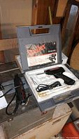 Weller soldering iron in gray case with accessories, placed on surface next to Craftsman rotary power tool