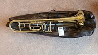 Full trombone assembled on top of case showing overall condition and included case