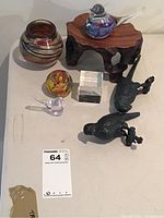 Overall view of all items in the lot showing glass bird figurines, wooden stand, black bird statues, vase, paperweight, and acrylic cube.